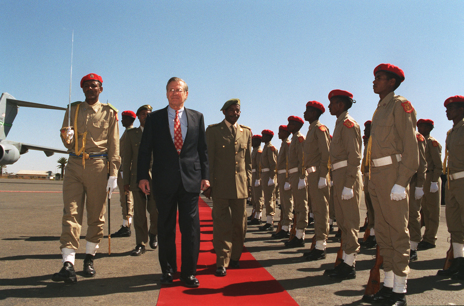 Министр обороны США Дональд Х. Рамсфелд (в центре) и министр обороны Эритреи генерал Себхат Эфрем (справа) на военном смотре во время приветственной церемонии 10 декабря 2002 года. Асмэре, Эритрея. Фото: Helene C. Stikkel 