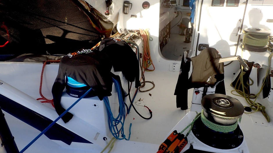 Thomas Covill dries wet clothes on board the Sodebo Utim during his attempt at a record single round-the-world trip.