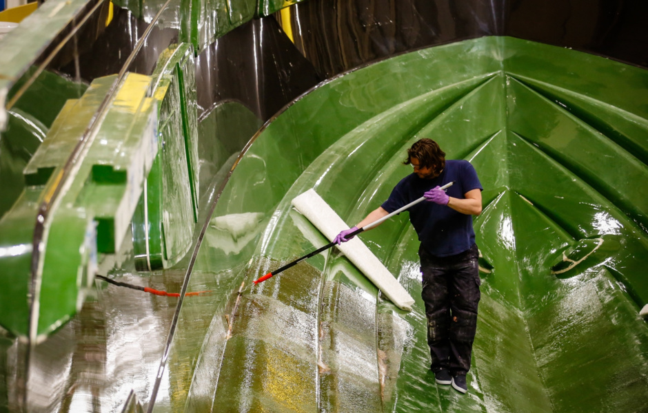 Working on a yacht hull in one of the large mold forms