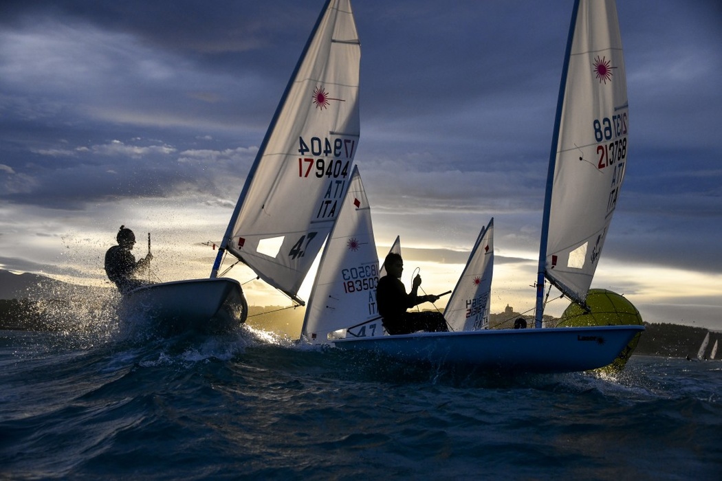 «The day was almost over, the results of the last Italia Cup #7 regatta in the Laser class were discussed. The light of the November day was gradually fading. We were on our feet all afternoon, everybody was tired, but the golden light that preceded the sunset created a magical atmosphere in the racing zone. I think this photo, taken behind the top sign, conveys the energy, tension and drama of the last minutes of the regatta»,