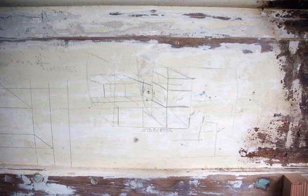 Sketches of what needs to be rebuilt are painted on the walls of the cabin. 