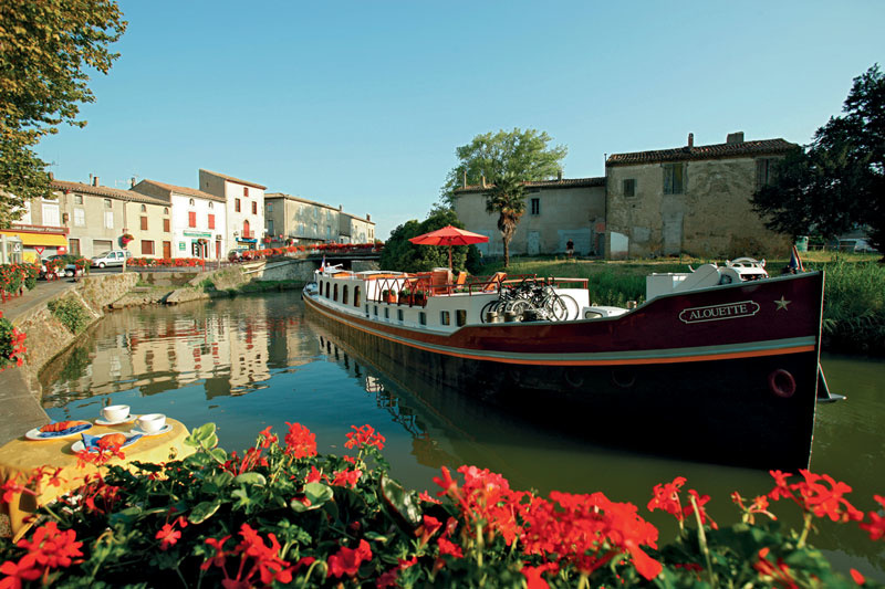 The two-story Alouette, the smallest barge in the flotilla, sails the Canal du Midi to the Fortress City of Carcassonne.