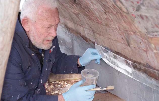 Sir Robin Knox-Johnston did most of the restoration work himself, where he prepares the iron keel before applying the protective tape.