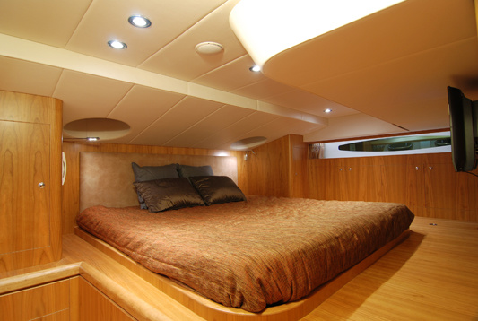 A staircase leads to the owner's cabin with a wide double bed and private shower room. Ceiling hatches above the bed allow natural lighting.