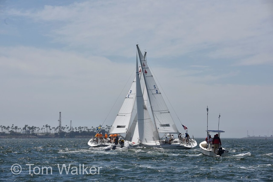 Match-race classic: boats in close combat, umpires watching a duel with water and making a decision in real time.