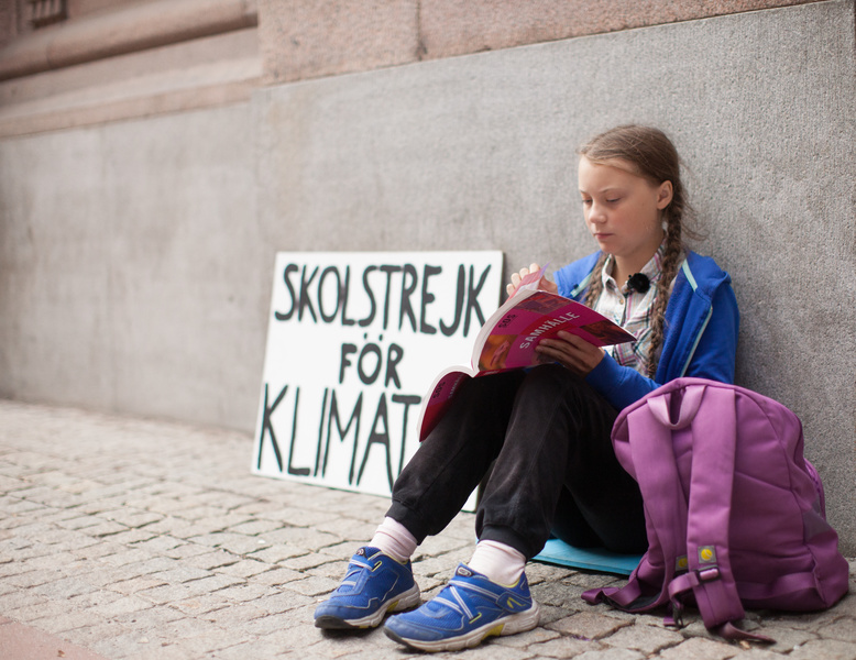 Бастующая Грета Тунберг у здания парламента в Швеции.